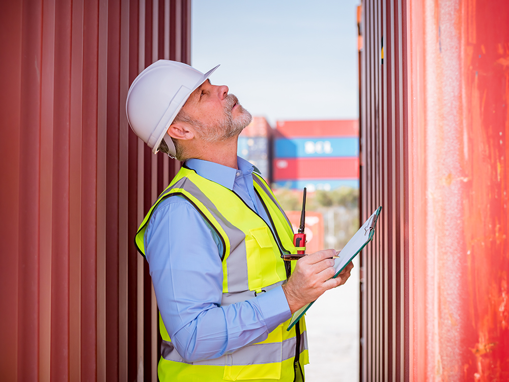 Inspector certificando contenedor marítimo en puerto para exportación internacional